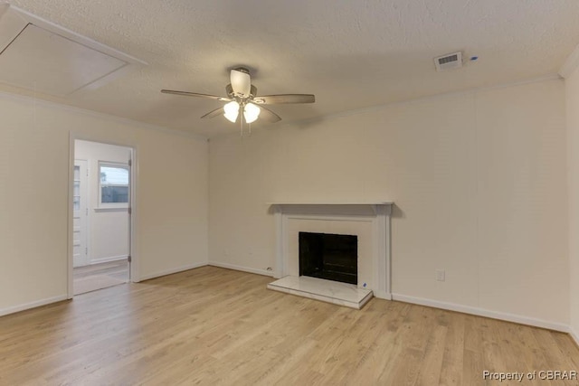 unfurnished living room featuring a textured ceiling, ceiling fan, crown molding, and light hardwood / wood-style flooring