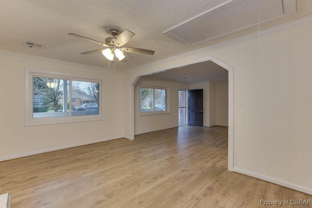 unfurnished room featuring a textured ceiling, light wood-type flooring, ceiling fan, and ornamental molding