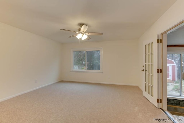 empty room featuring ceiling fan, light colored carpet, and french doors