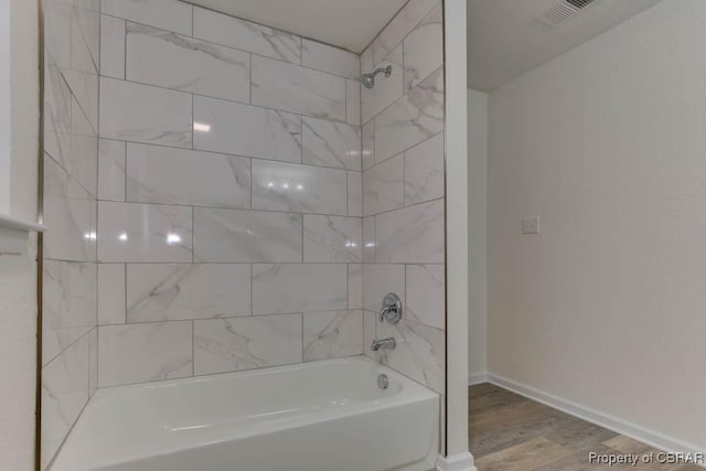 bathroom with wood-type flooring and tiled shower / bath combo