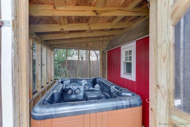 sunroom featuring lofted ceiling and a jacuzzi