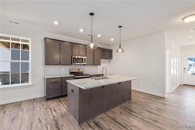 kitchen featuring light stone countertops, sink, light hardwood / wood-style floors, dark brown cabinets, and appliances with stainless steel finishes