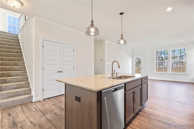 kitchen featuring light stone countertops, dishwasher, sink, light hardwood / wood-style floors, and a kitchen island with sink