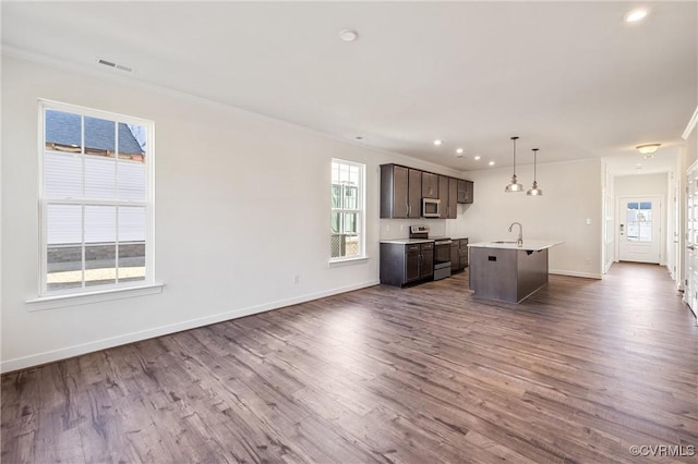 unfurnished living room featuring hardwood / wood-style floors, plenty of natural light, and ornamental molding