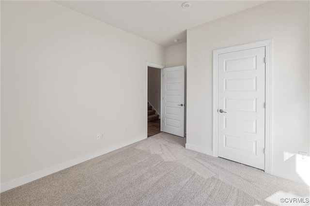 unfurnished bedroom with light carpet and a closet