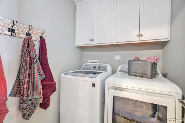 clothes washing area with cabinets and independent washer and dryer