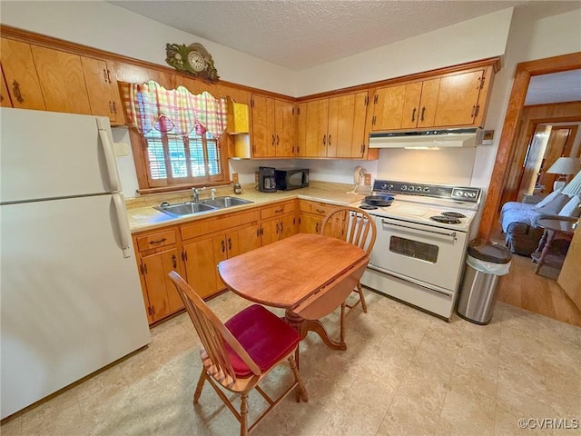 kitchen with a textured ceiling, white appliances, and sink