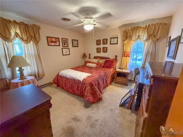 bedroom with multiple windows, ceiling fan, carpet floors, and a textured ceiling