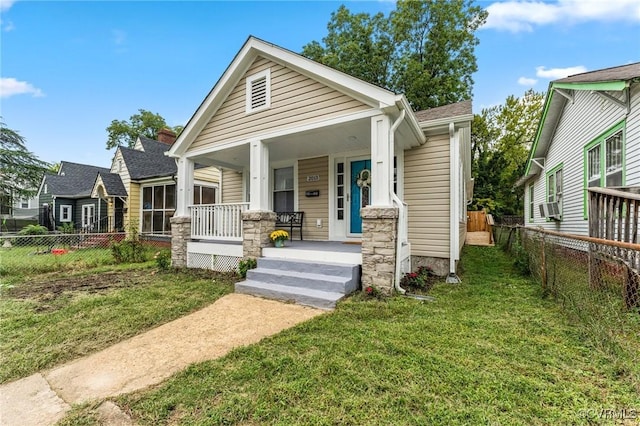 view of front of property featuring a porch, a front lawn, and cooling unit