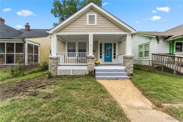 view of front of home with covered porch and a front lawn