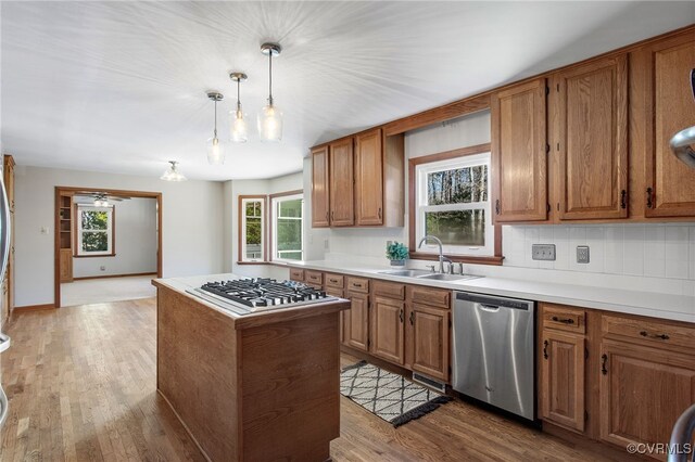 11741 Riverpark Dr, Chesterfield, VA 23838 - kitchen with a center island, a sink, light wood-style floors, brown cabinetry, and stainless steel appliances