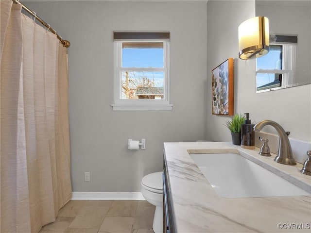 bathroom with plenty of natural light, vanity, and toilet