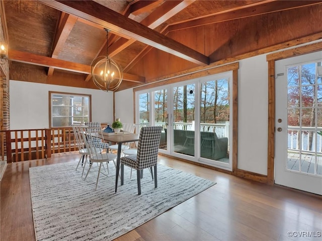 sunroom featuring lofted ceiling with beams, wooden ceiling, a wealth of natural light, and an inviting chandelier