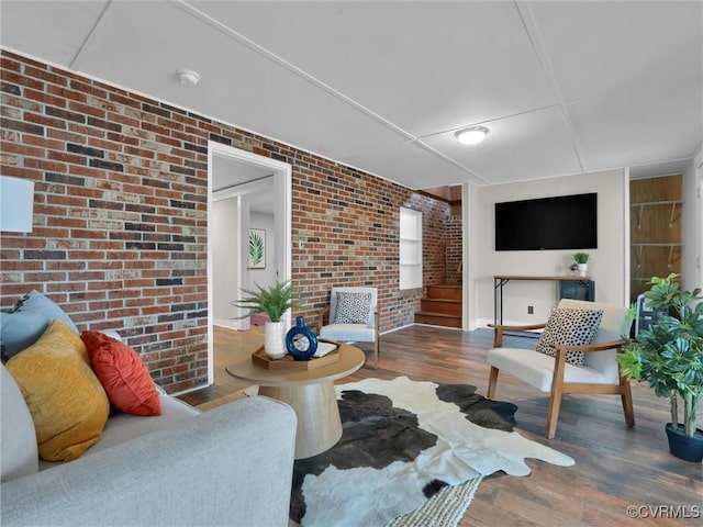 living room featuring hardwood / wood-style floors and brick wall