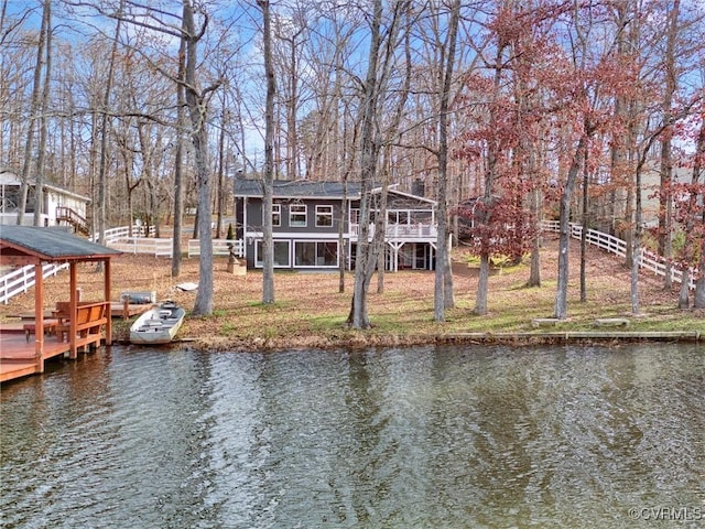 dock area featuring a lawn and a deck with water view