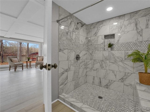 bathroom with a tile shower, beamed ceiling, wood-type flooring, and coffered ceiling