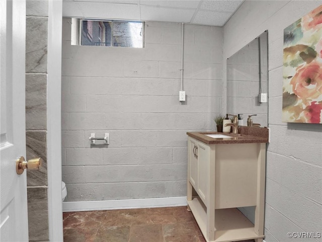 bathroom featuring a drop ceiling, vanity, and toilet