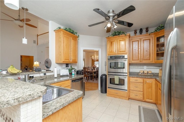 kitchen featuring pendant lighting, stainless steel appliances, sink, kitchen peninsula, and light tile patterned flooring