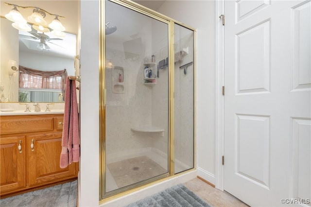 bathroom featuring vanity, ceiling fan with notable chandelier, and an enclosed shower