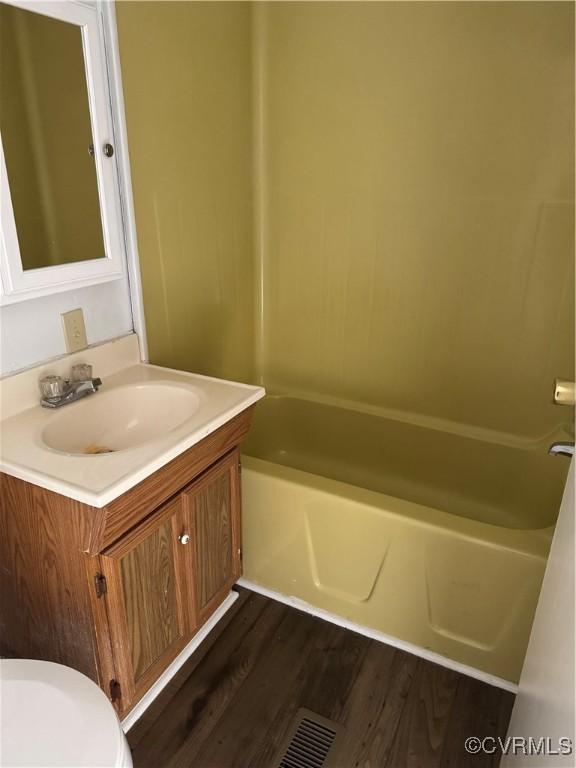 bathroom featuring wood-type flooring, vanity, and toilet