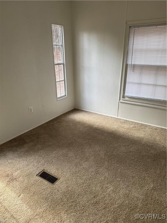 carpeted spare room featuring plenty of natural light