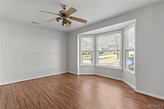 empty room with hardwood / wood-style floors and ceiling fan