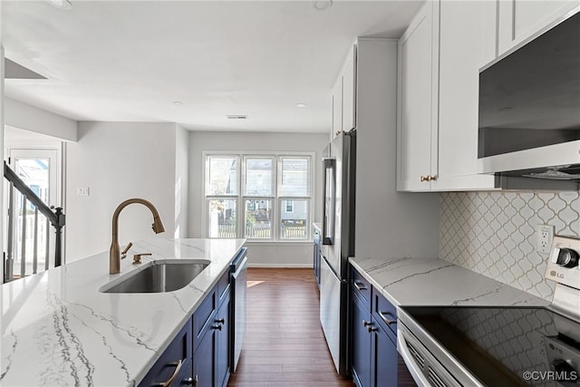 kitchen featuring blue cabinetry, stainless steel appliances, and light stone countertops