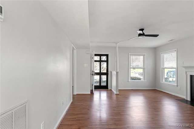 unfurnished living room with ceiling fan and dark wood-type flooring