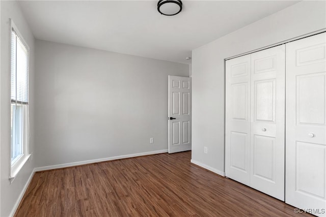 unfurnished bedroom featuring dark hardwood / wood-style flooring and a closet