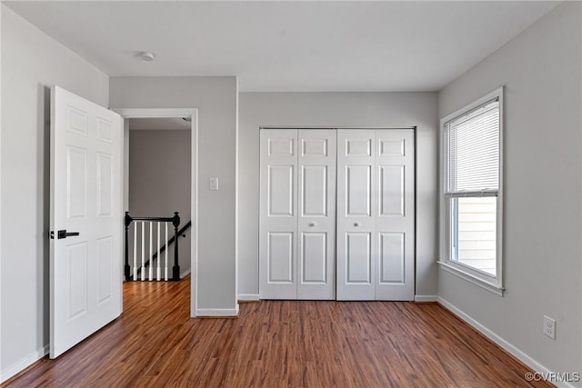 unfurnished bedroom featuring a closet and dark hardwood / wood-style floors