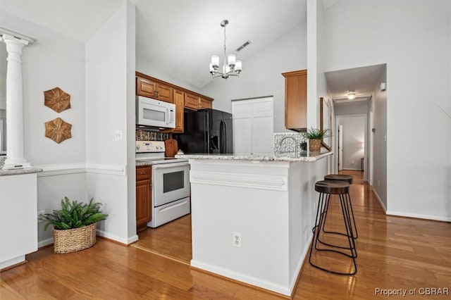 kitchen with hardwood / wood-style floors, white appliances, and high vaulted ceiling