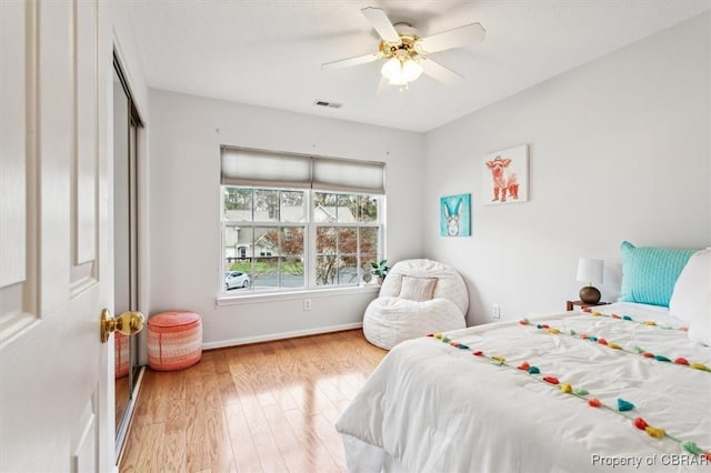 bedroom with ceiling fan, light hardwood / wood-style floors, and a closet