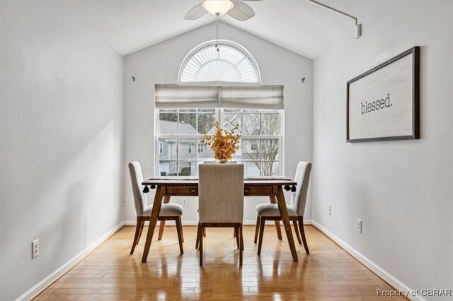 dining area with a textured ceiling, ceiling fan, vaulted ceiling, and hardwood / wood-style flooring