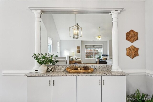 interior space featuring white cabinets, light stone counters, ceiling fan, and lofted ceiling