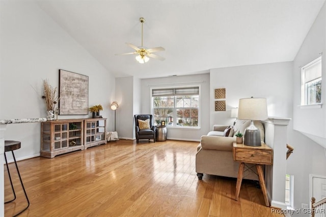 sitting room with wood-type flooring, high vaulted ceiling, and ceiling fan