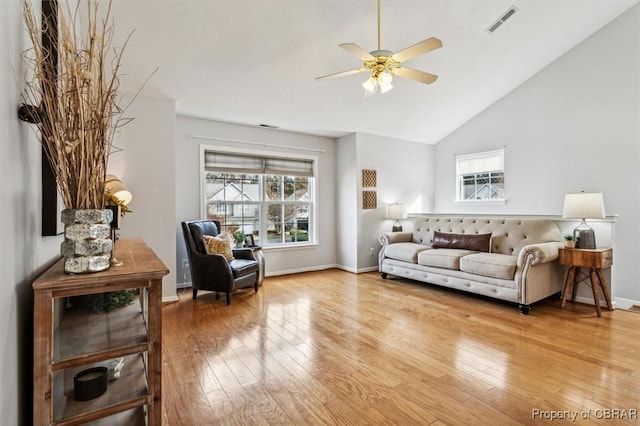 living room with ceiling fan, high vaulted ceiling, and wood-type flooring