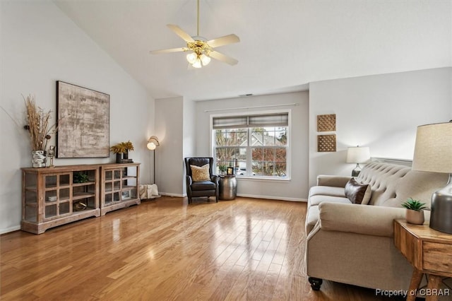 living room with hardwood / wood-style floors, ceiling fan, and vaulted ceiling