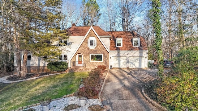 english style home featuring a garage and a front yard