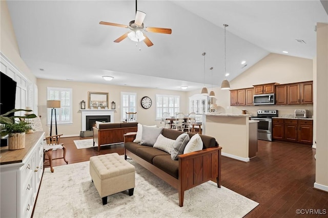 living room with ceiling fan, dark hardwood / wood-style flooring, and high vaulted ceiling