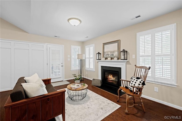 living area featuring a wealth of natural light and dark hardwood / wood-style flooring