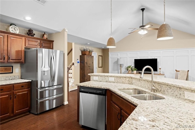 kitchen with ceiling fan, sink, light stone counters, dark hardwood / wood-style floors, and appliances with stainless steel finishes