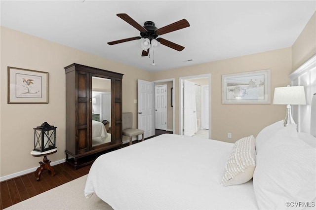 bedroom featuring ensuite bath, ceiling fan, and dark wood-type flooring