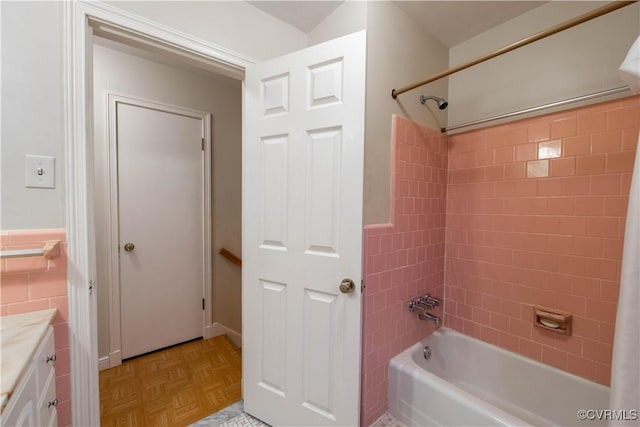 bathroom with vanity, parquet floors, and tiled shower / bath combo