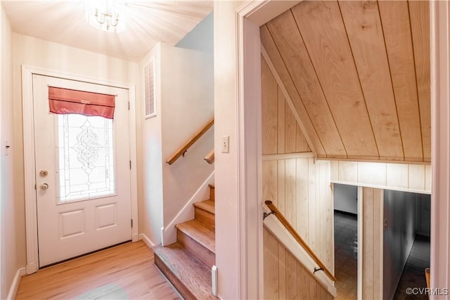 entryway featuring hardwood / wood-style flooring and wooden walls