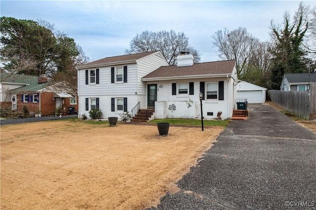 tri-level home featuring a garage, an outbuilding, and a front lawn