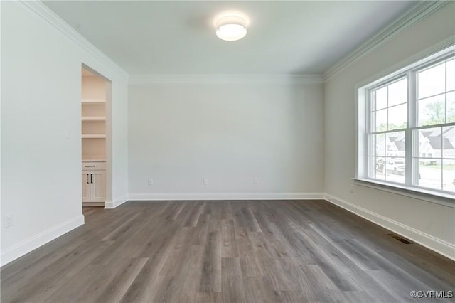 spare room with crown molding and dark wood-type flooring