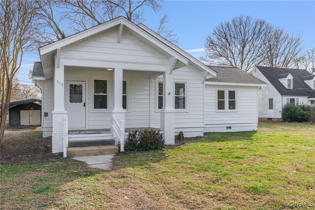 bungalow-style house with a carport, covered porch, and a front lawn