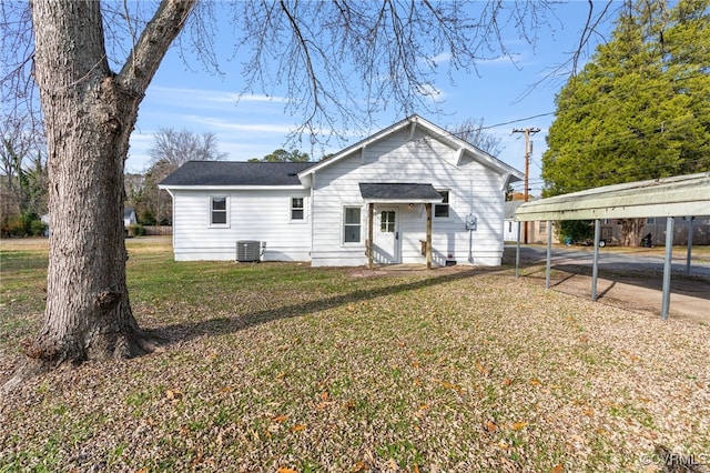 back of property with a carport, a yard, and central air condition unit