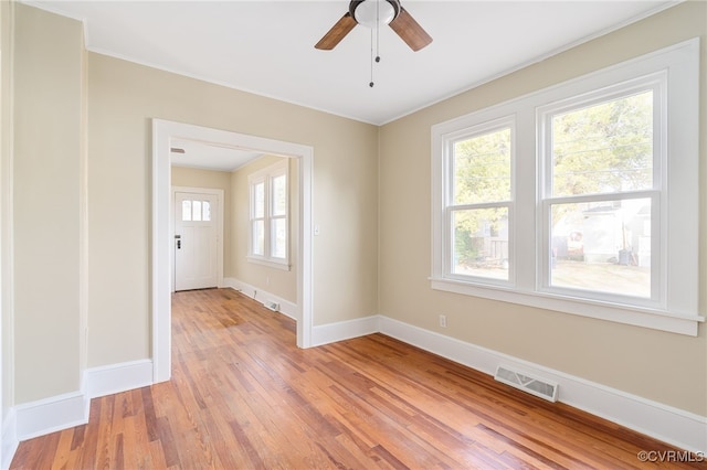 spare room with ceiling fan, light wood-type flooring, and crown molding