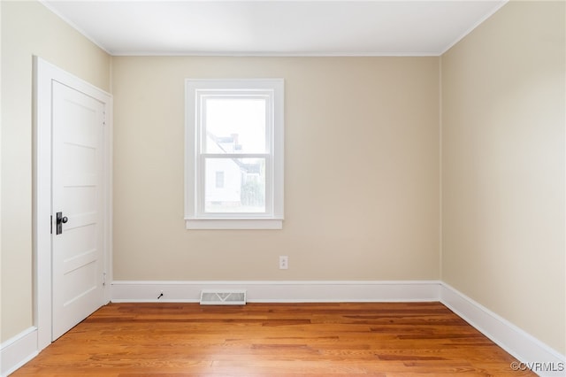 empty room featuring light hardwood / wood-style flooring and ornamental molding